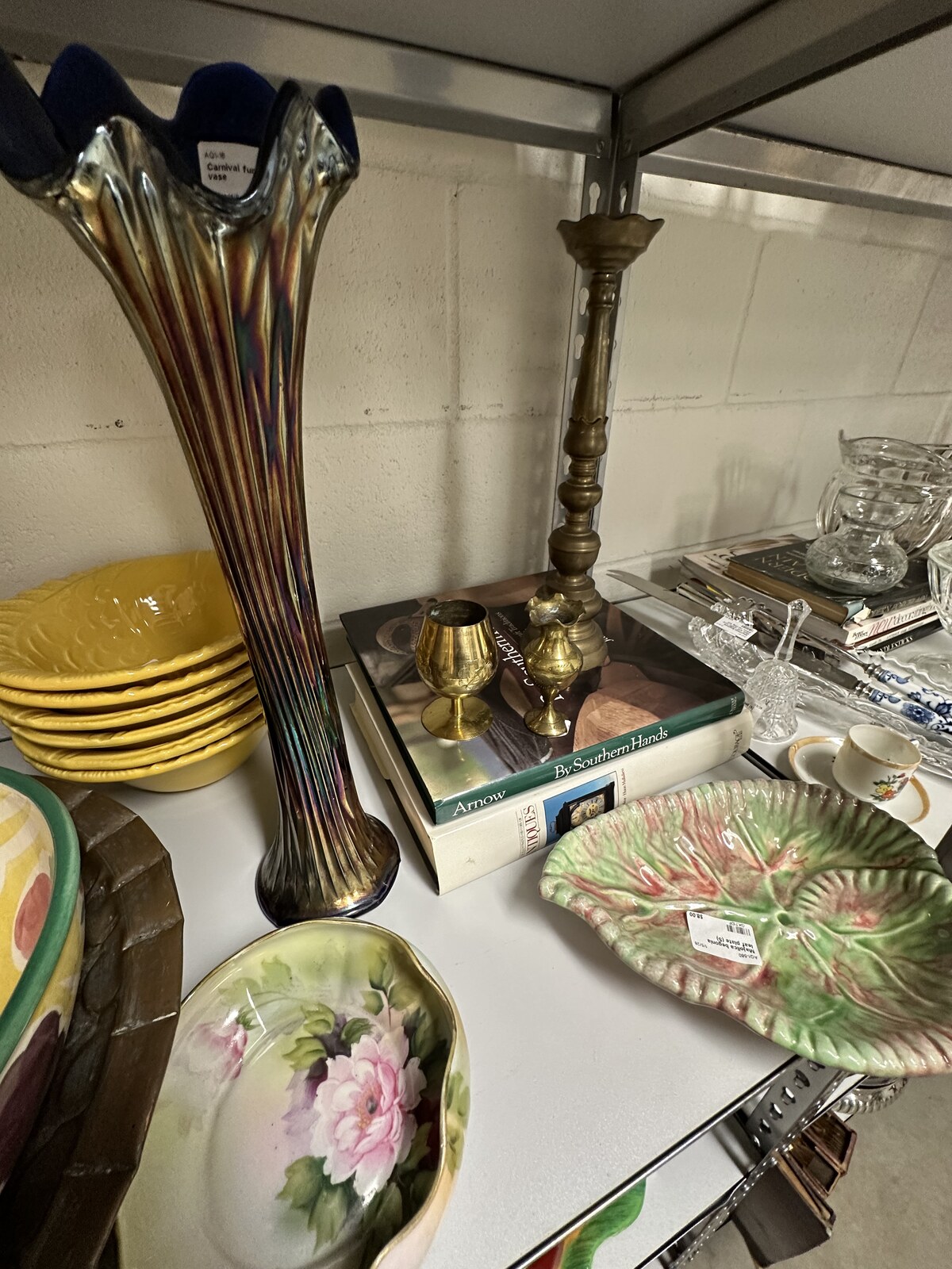 Consignment shelf with vintage decor, dishes, and display pieces at Triangle Trading Post