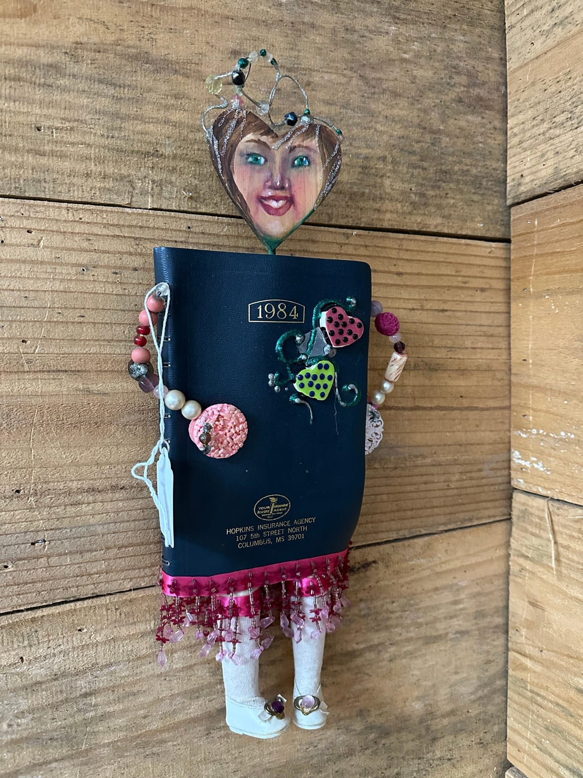 Mixed-media assemblage figure with painted face and found objects by Adele Elliott