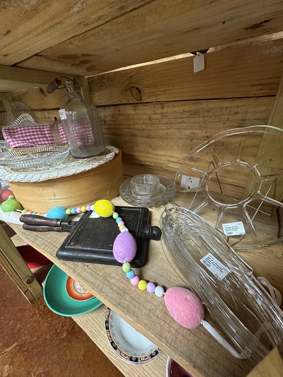 Vintage glassware and collectibles on wooden shelves at Amy's Attic