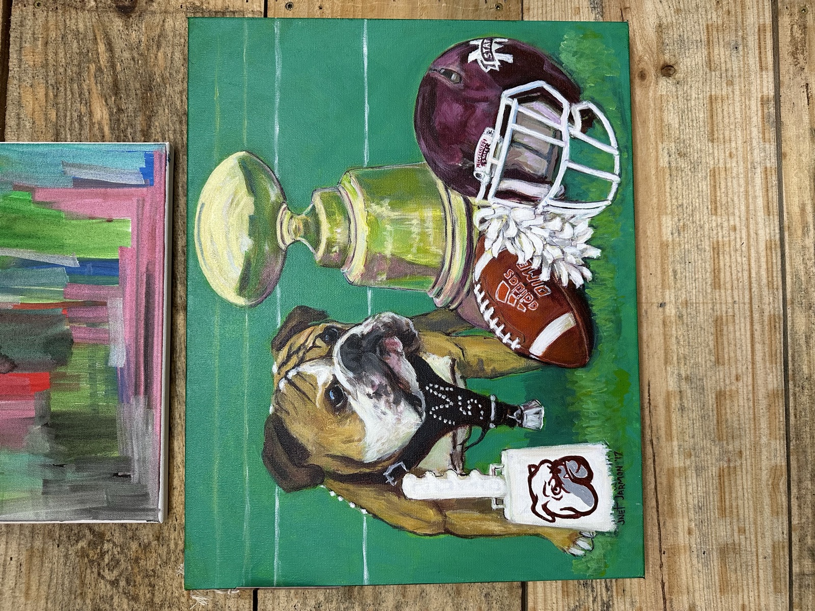 Painting of Mississippi State Bulldog mascot with football helmet and trophy
