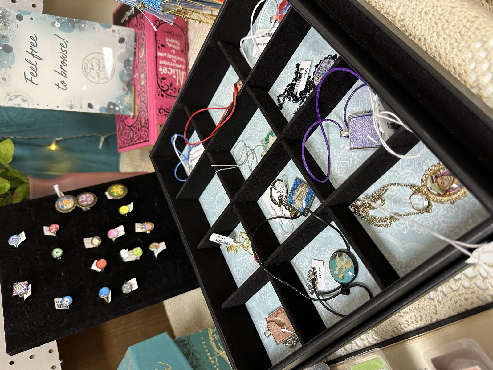 Handmade jewelry, pendants, and rings displayed in a compartmented display case