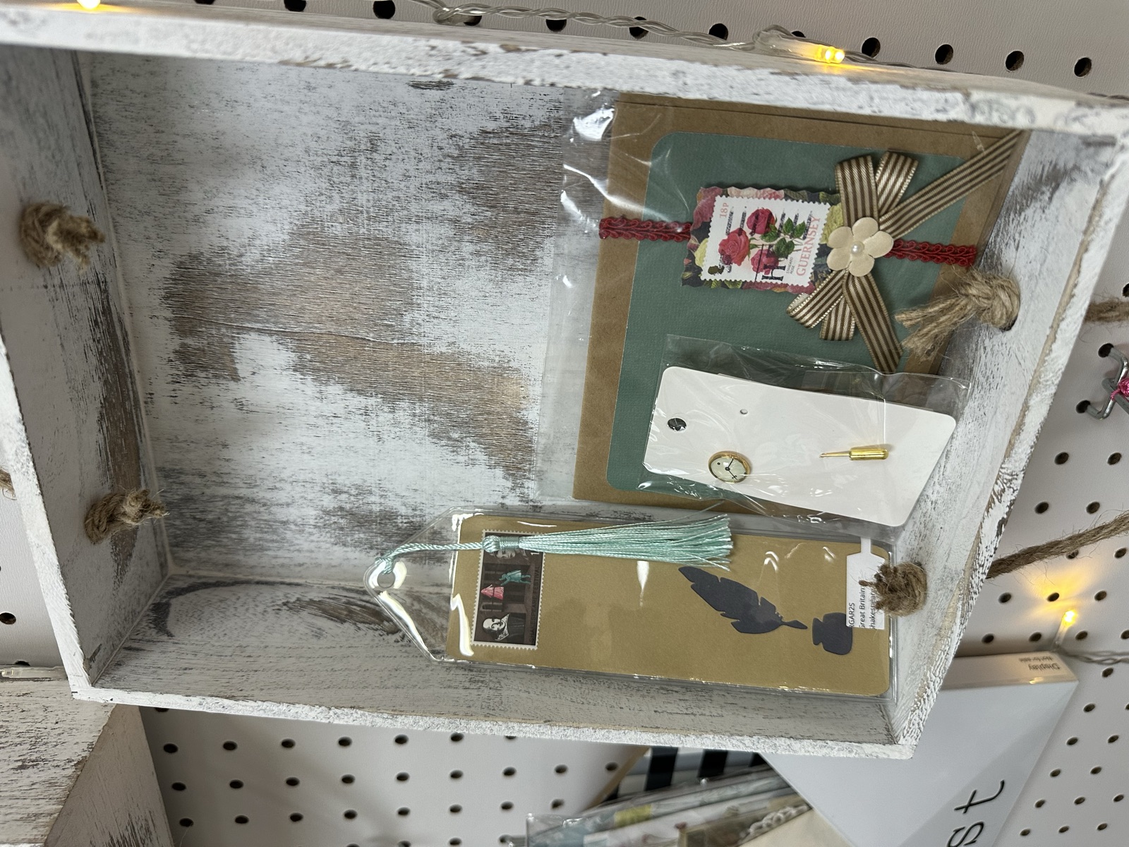 Distressed wooden tray with mixed-media art pieces, bookmarks, and tassels