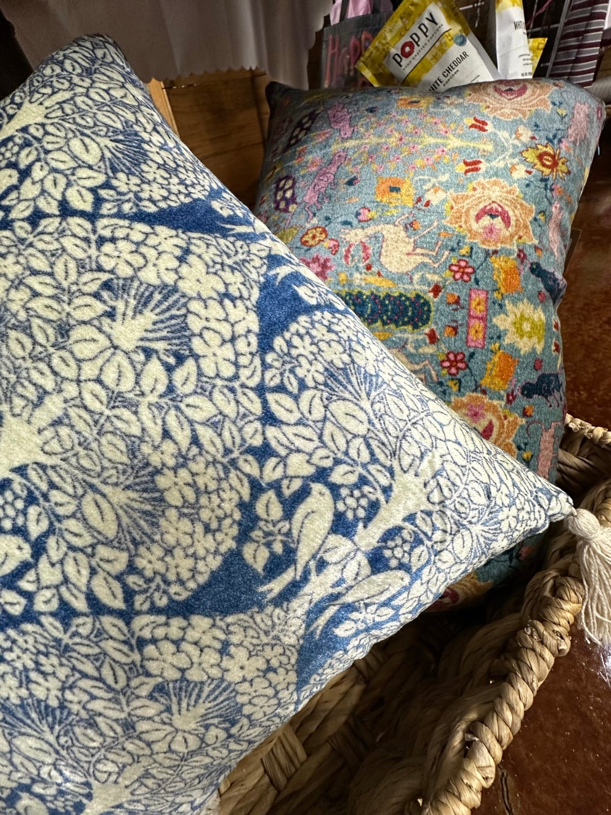 Decorative throw pillows in blue floral and colorful folk patterns at the Blondies booth