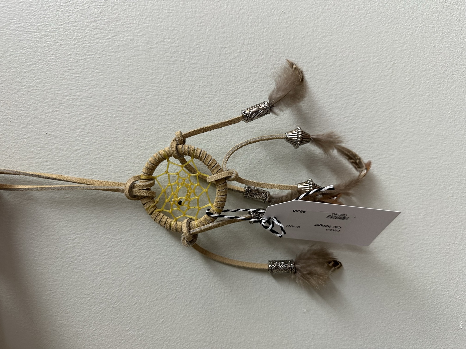 Small tan dreamcatcher with yellow webbing and silver accents
