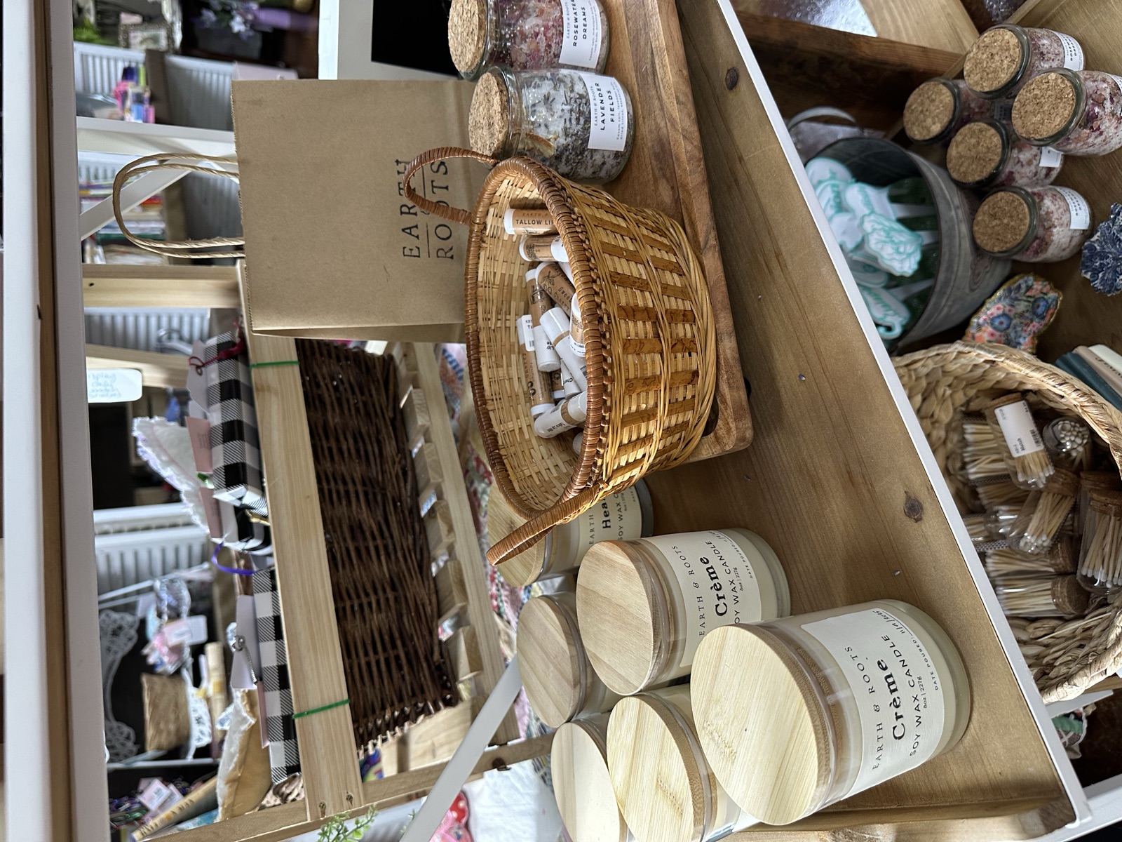 Candles, woven baskets, and natural bath products on wooden shelves