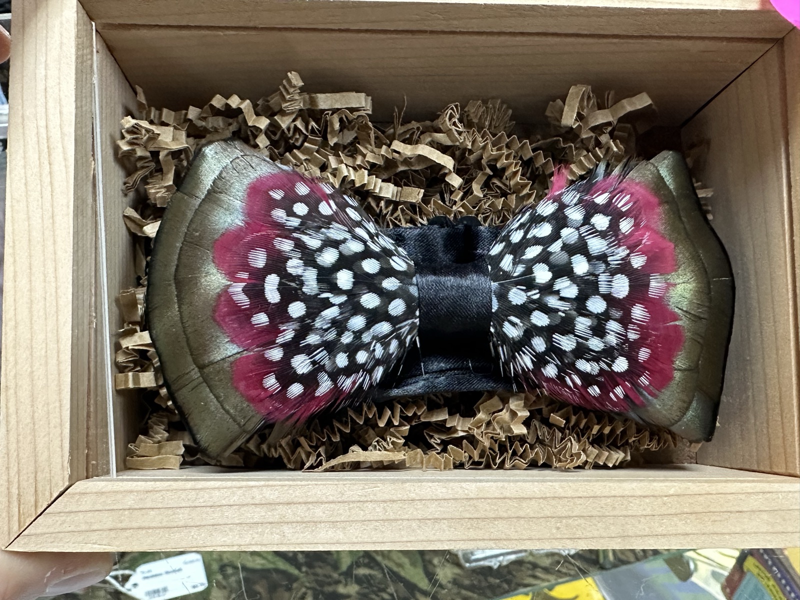 Handmade feather bow tie with pink and spotted guinea fowl feathers in a wooden gift box