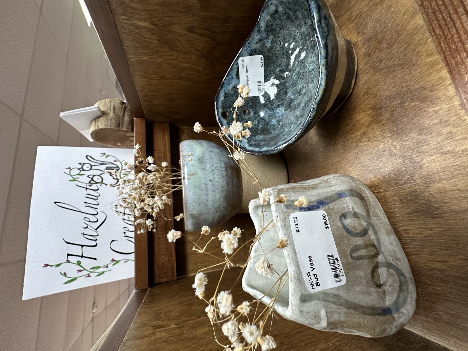 Hazelnut Creations display with ceramic vessels and dried flowers inside Triangle Trading Post