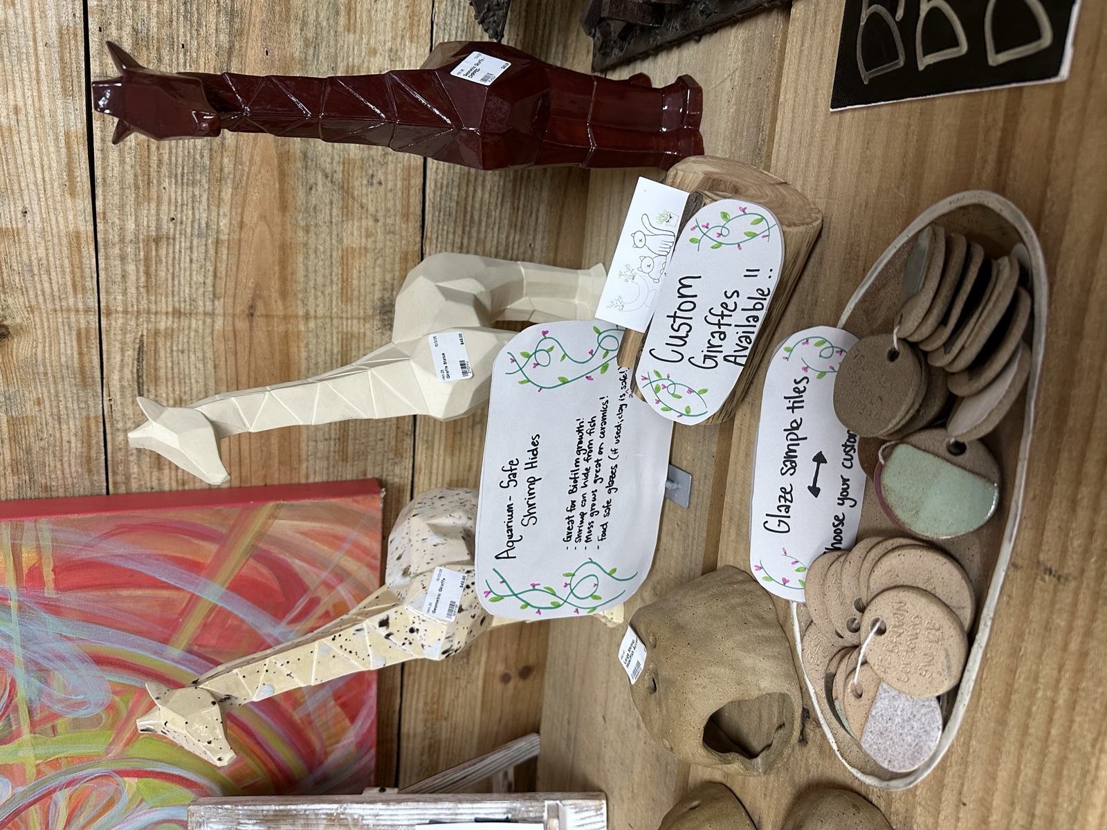 Ceramic guitar figures and custom glaze sample tiles on a wooden display