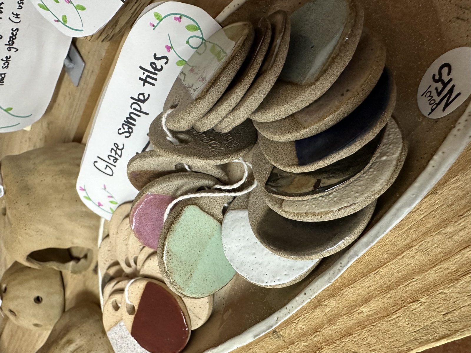 Ceramic glaze sample tiles in assorted colors displayed in a bowl