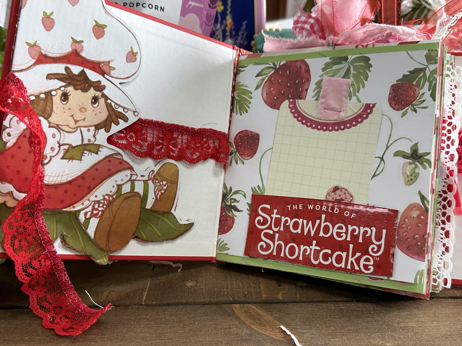 Strawberry Shortcake journal pages with vintage character art and red lace ribbon