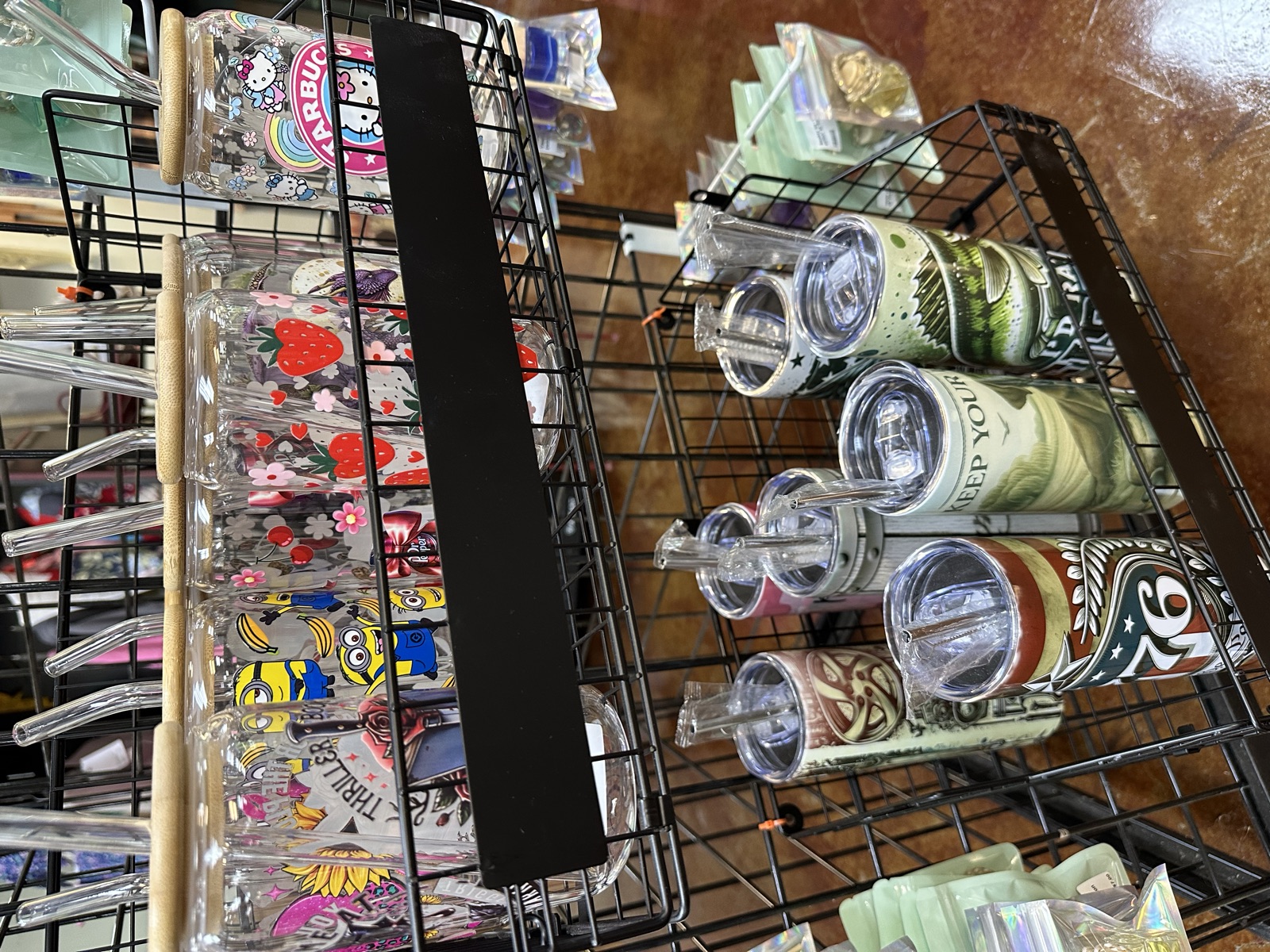 Wire rack display with colorful stickers, iron-on patches, and branded tumblers