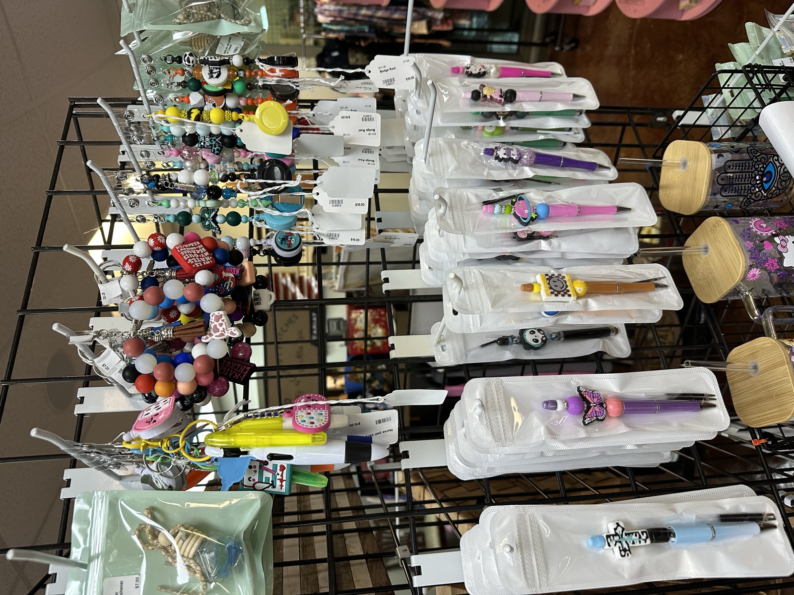 Beaded pens, keychains, and badge reels on a wire rack display