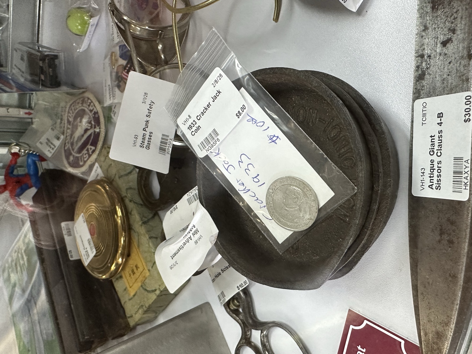 Vintage coins, brass items, and small collectibles on display