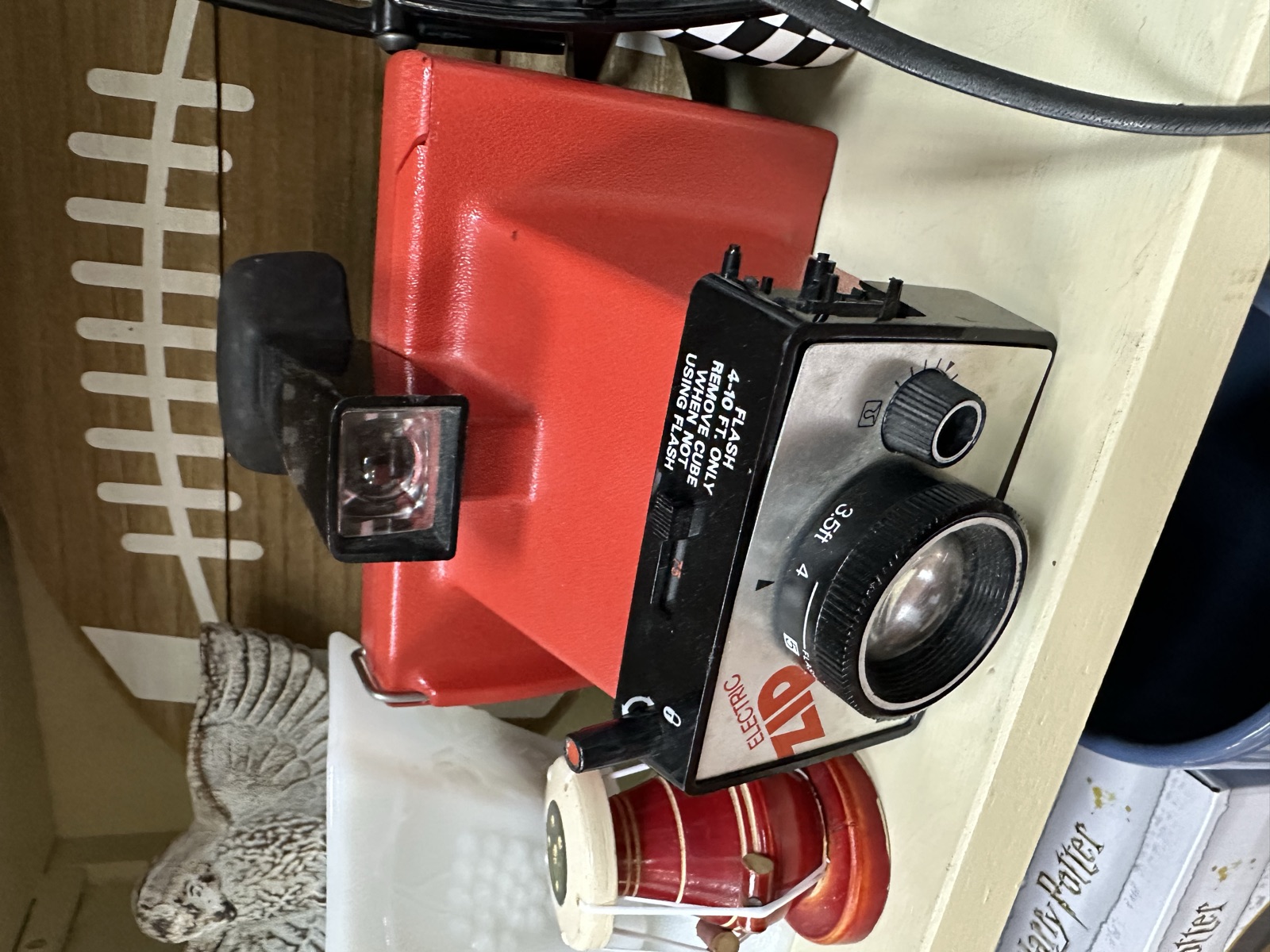 Vintage red and black camera and collectibles on a shelf